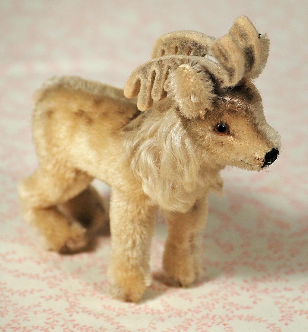 STEIFF “RENNY REINDEER”.: STEIFF “RENNY REINDEER”. 5 1/2" h. Plush spotted mohair with fluffy neck ruff, felt antlers, black floss nose, and felt antlers, no ear button. Commentary: 1960, very good condition.