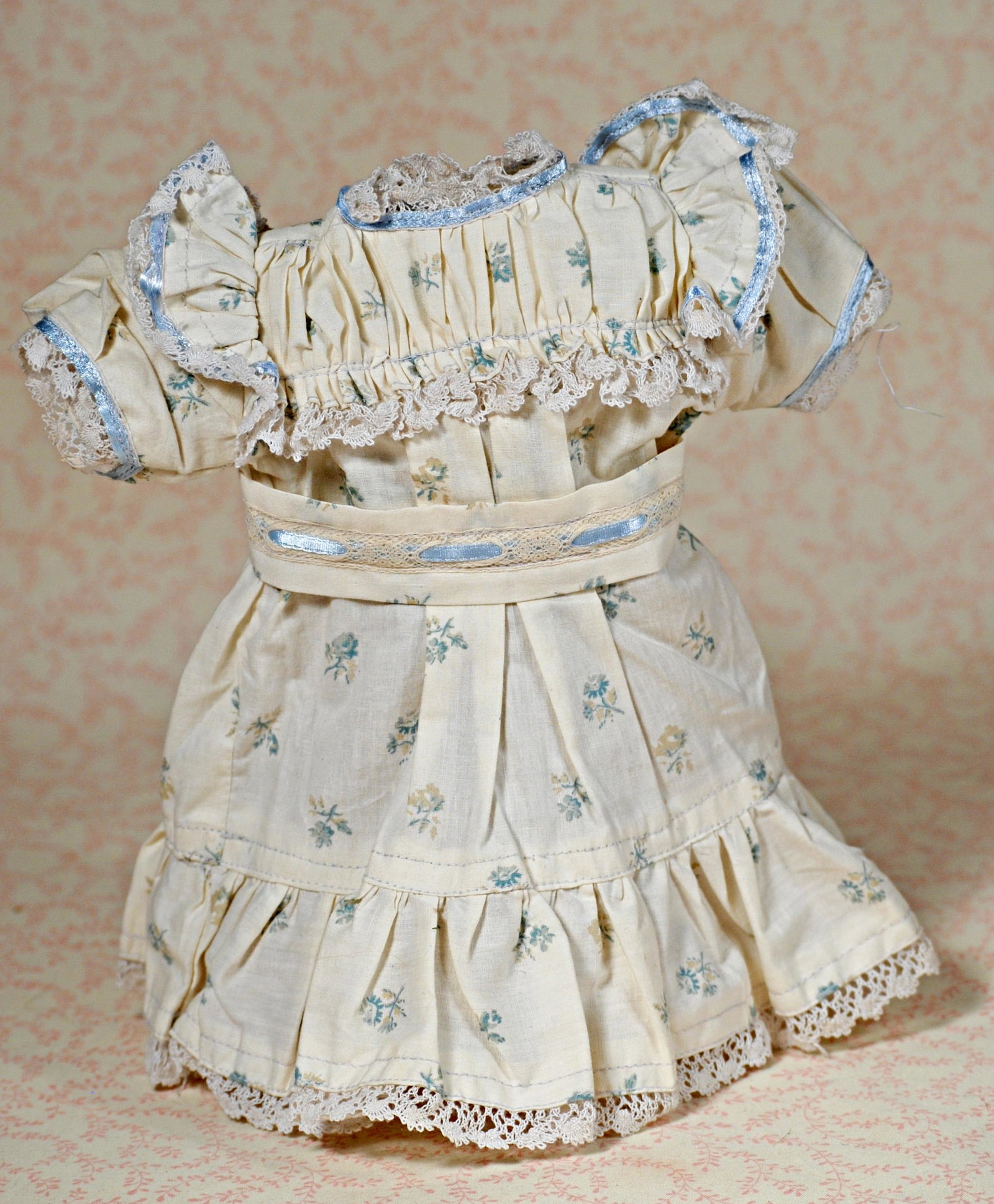 BEBE JUMEAU COTTON DRESS.: BEBE JUMEAU COTTON DRESS. Blue and white cotton print with gathered yoke, short puffed sleeves, pleated skirt, flounce with lace edging, blue ribbon trim, 4" shoulder width, 9" length. Contemporary ma