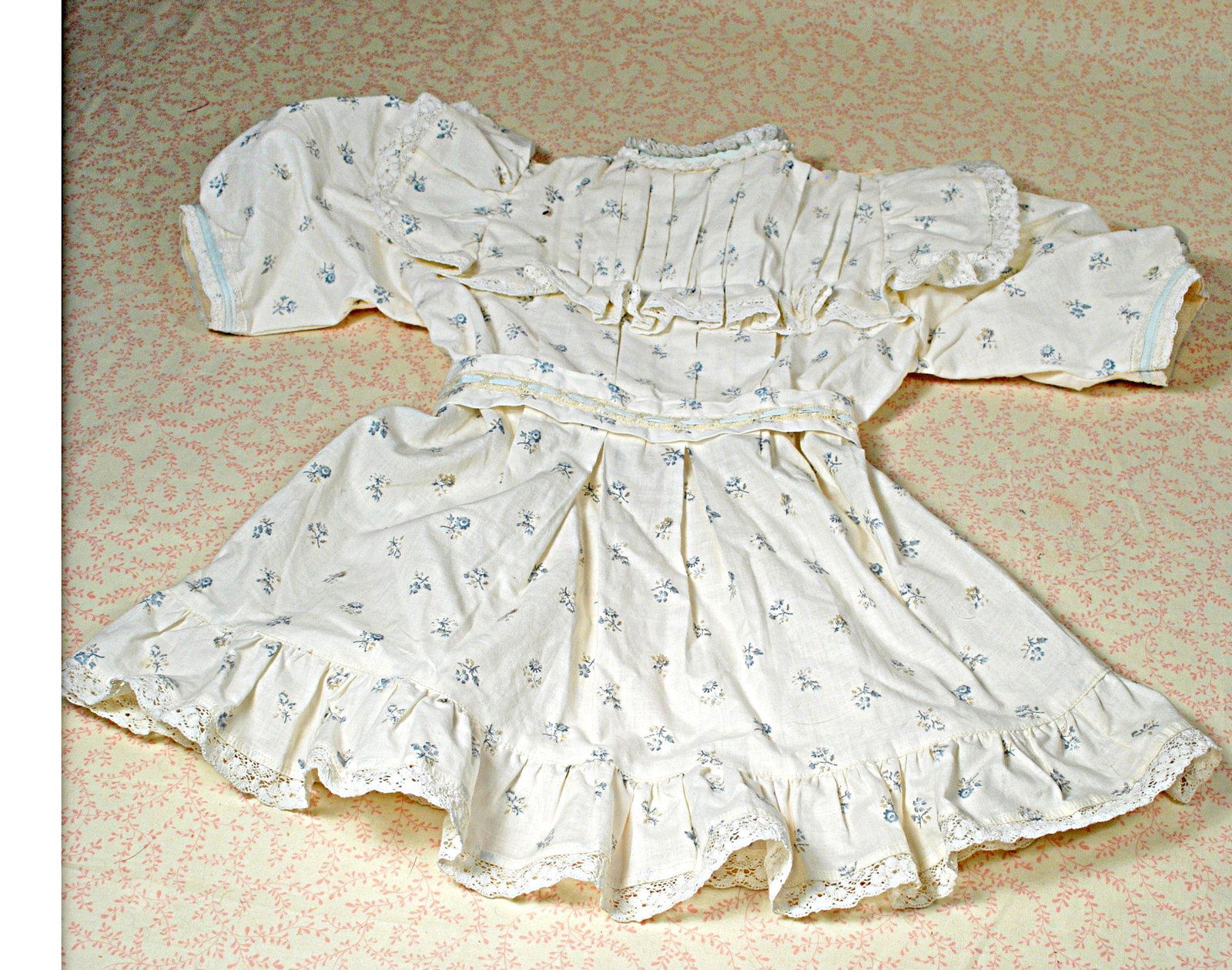 BEBE JUMEAU COTTON DRESS.: BEBE JUMEAU COTTON DRESS. Blue and white cotton print, gathered yoke, puffed sleeves, pleated skirt, flounce with lace edging, blue ribbon trim, 8” shoulder width, 19" length. Contemporary maker, ex