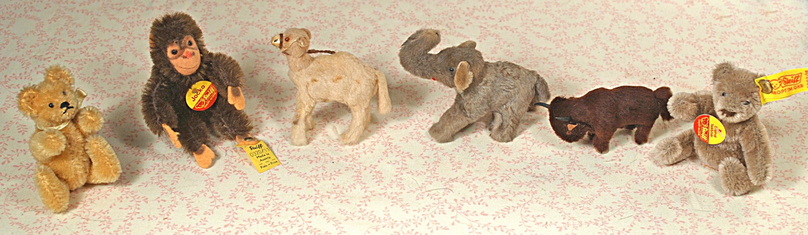 SIX MINIATURE GERMAN ANIMALS.: SIX MINIATURE GERMAN ANIMALS. Includes: Blonde mohair fully jointed teddy bear; Steiff mohair Monkey with tags and button; camel, elephant and buffalo with Made in German circular stickers; Steiff gra