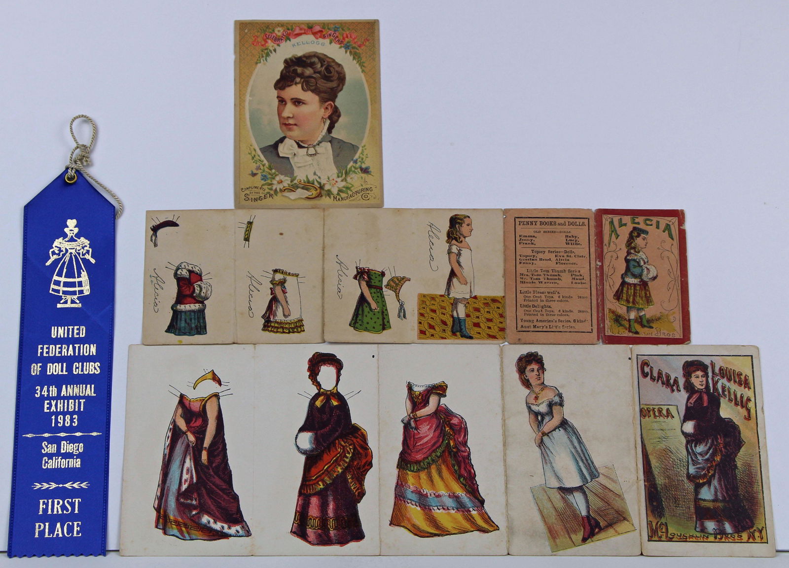 TWO MCLOUGHLIN BROS FOLDING BOOKS, ONE SEWING MACHINE: TWO MCLOUGHLIN BROS FOLDING BOOKS, ONE SEWING MACHINE CARD, LATE 1800s. 3” Alecia uncut doll with 3 costumes; 4 1.2” Clara, the Opera singer doll with 3 uncut dresses; 3 ½” x 4 ½” Clara Loui