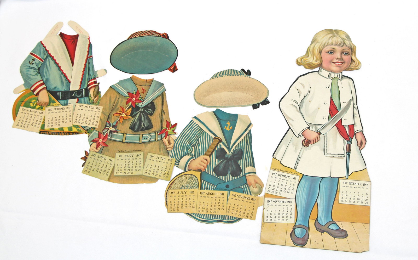 THREE ADVERTISEMENT CUT OUT CALENDARS PAPER DOLLS, 1917: THREE ADVERTISEMENT CUT OUT CALENDARS PAPER DOLLS, 1917. 19" paper dolls Donald, Clarabel, and Sylvia, each with three extra costumes and hats (Clarabel has an extra dress). Advertisements information