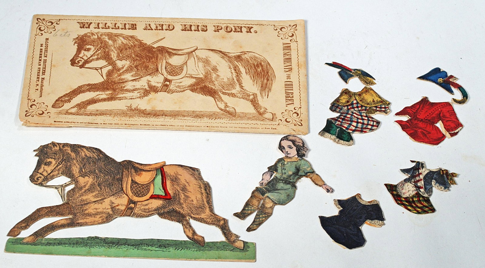 RARE 1858 MCLOUGHLIN BROS "WILLIE AND HIS PONY" PAPER: RARE 1858 MCLOUGHLIN BROS "WILLIE AND HIS PONY" PAPER DOLL WITH ENVELOPE & OUTIFTS. Envelope 7" x 3 3/4" with directions printed on flap; Includes Willie, four costumes, two hats, pony (missing tail).