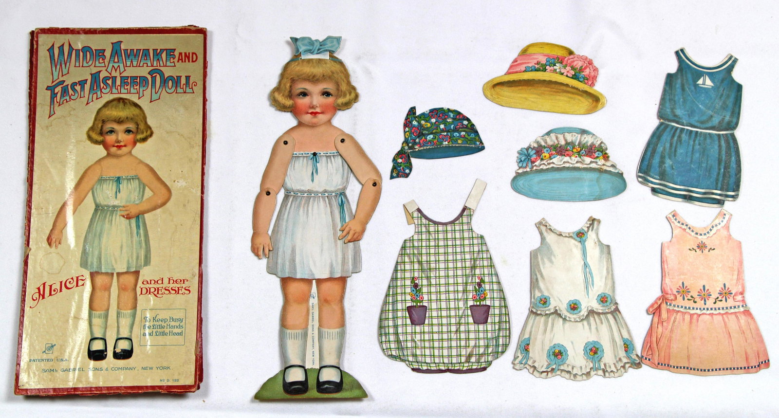 BOXED PAPER DOLL "WIDE AWAKE AND FAST ASLEEP DOLL: BOXED PAPER DOLL "WIDE AWAKE AND FAST ASLEEP DOLL ALICE" BY GABRIEL . 12 1/2" cardstock doll with jointed shoulders and elbows, easel-back, and sleeping eyes that open and close by pulling and pushing