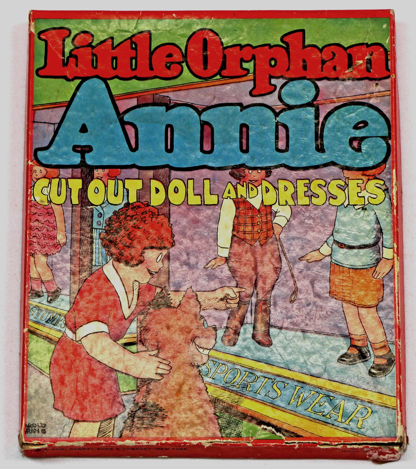 LITTLE ORPHAN ANNIE CUT-OUT DOLL & DRESSES BY GABRIEL: LITTLE ORPHAN ANNIE CUT-OUT DOLL & DRESSES BY GABRIEL. 8" x 9 3/8" deep cardboard box w/glossy illustrated lid contains set No. D. 113 by Samuel Gabriel Sons & Company. 1930s. Underside of lid has six