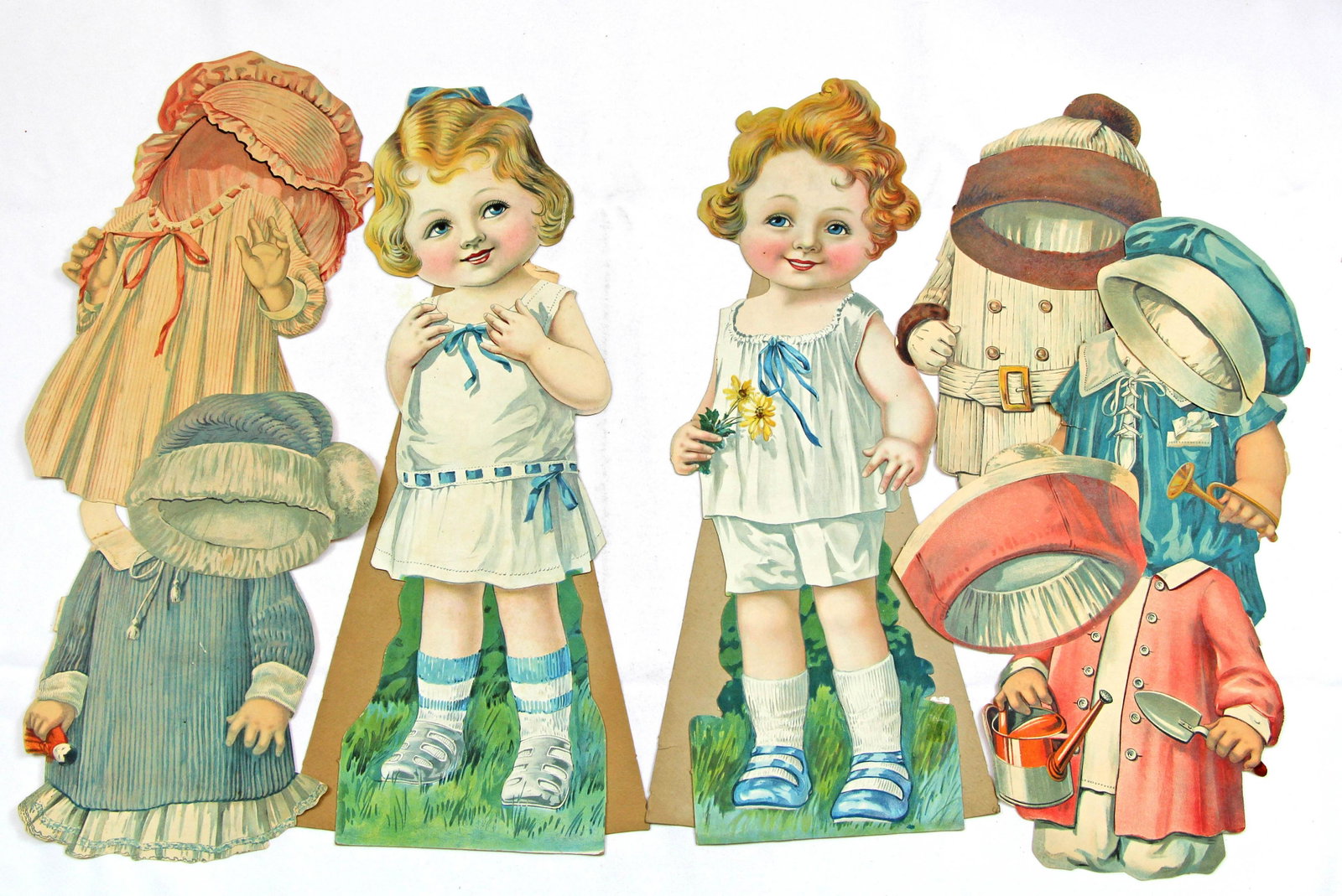 THREE JUVENILLE DRESSING DOLLS SETS FROM WOOLWORTH: THREE JUVENILLE DRESSING DOLLS SETS FROM WOOLWORTH 1917-1918 SERIES. 21" Single-sided cardboard dolls. 1917 series has Mabel (set 1) with 3 dresses and hats; 1918 series includes Vincent with 3 outfit