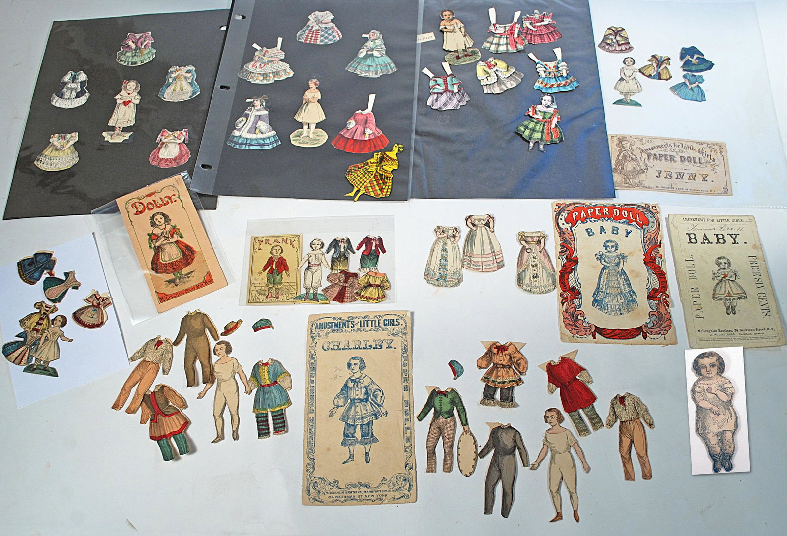 GROUP OF EARLY PENNY PAPER DOLLS BY MCLOUGHLIN: GROUP OF EARLY PENNY PAPER DOLLS BY MCLOUGHLIN. 2 1/2" to 3 3/4" dolls. Includes: Two Charley dolls with nine costumes, one original envelope; Frank with four costumes and booklet; Lucy with five dres