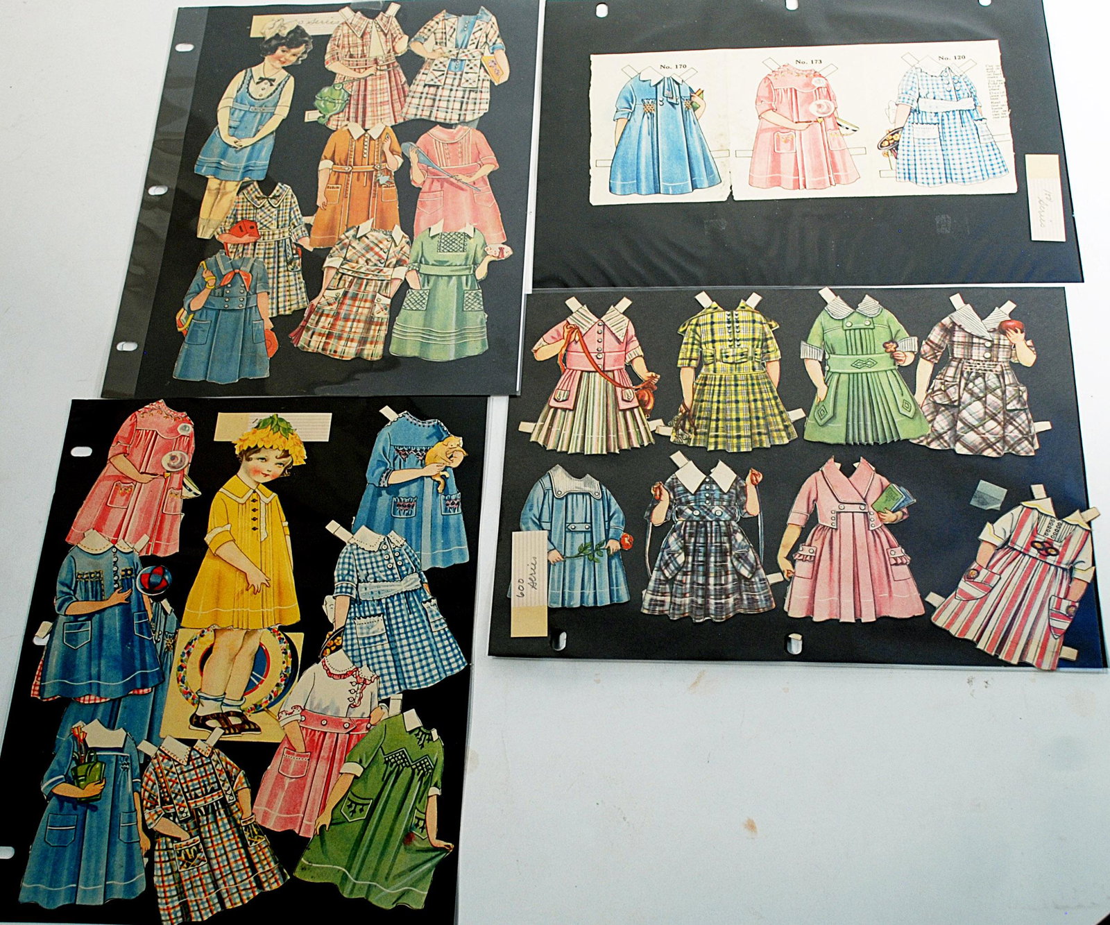 BINDER OF ELISIE DINSMORE PAPER DOLLS: BINDER OF ELISIE DINSMORE PAPER DOLLS. 12" x 9" binder with 11 pages of cut-out dolls and costumes, identified as series 100,200,500,600 and 1500; plus Marshall Fields paper doll, per Cynthia’s note