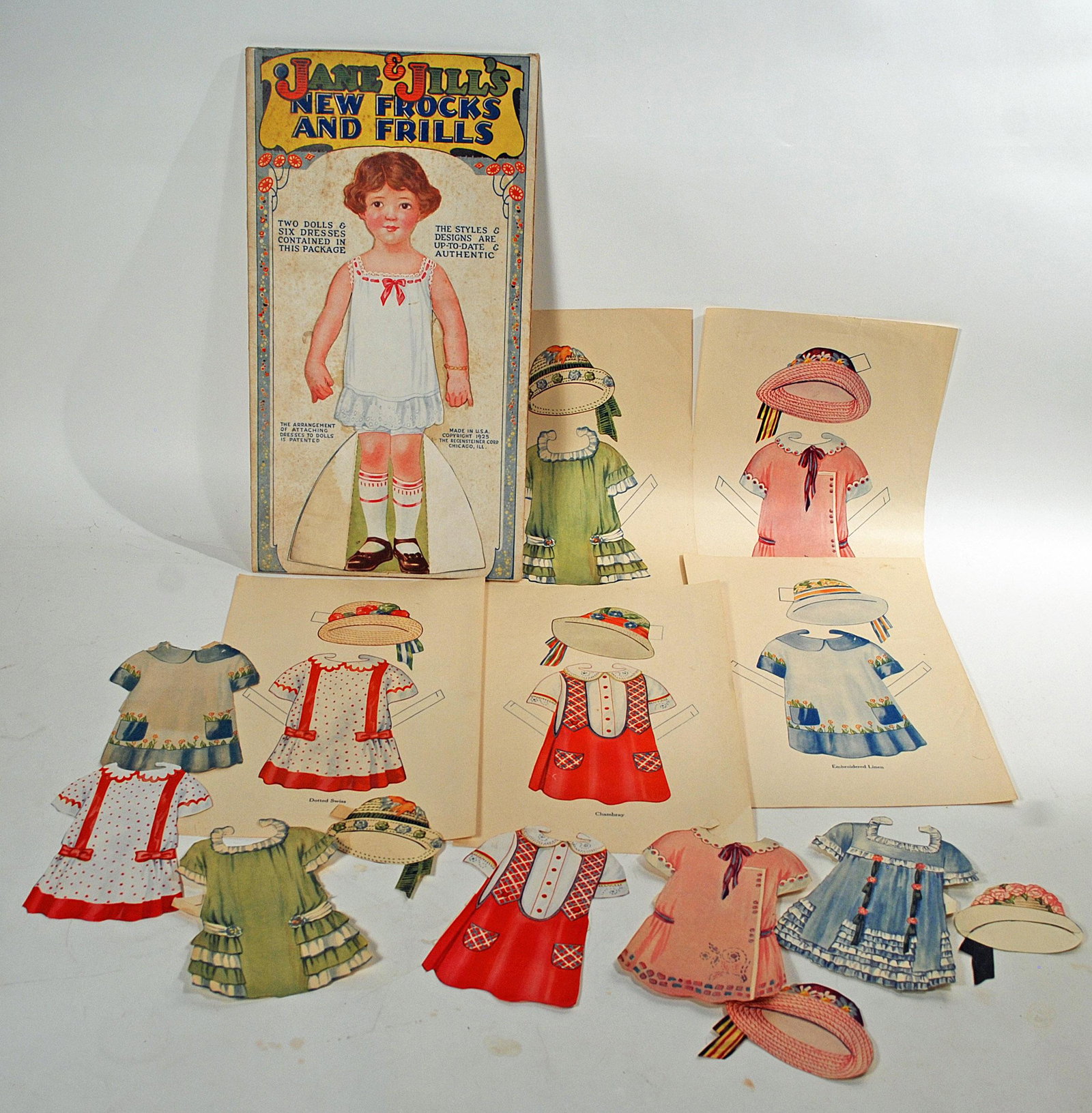 1925 JANE & JILL’S NEW FROCKS AND FRILLS BY: 1925 JANE & JILL’S NEW FROCKS AND FRILLS BY REGENSTEINER. Two 12 1/2" dolls and outfits. The outfits of this doll are unique as the dresses' color serves as a hook to attach the clothing to the doll