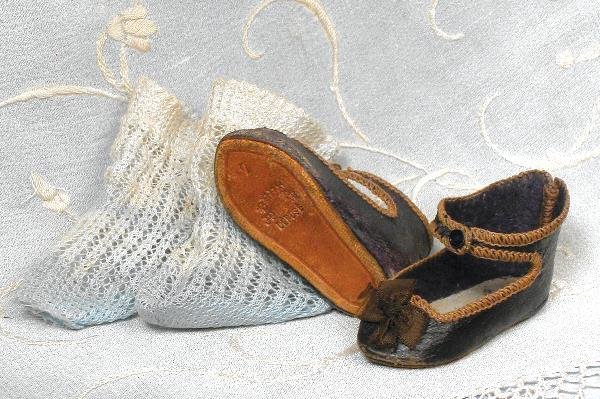 PAIR "BEBE JUMEAU" SHOES AND SOCKS. Marks: 7/ Be: PAIR "BEBE JUMEAU" SHOES AND SOCKS. Marks: 7/ Bebe Jumeau Depose. 2 ½" L. pair of dark leather shoes with ankle strap closing, overcast edges and silk bows; plus pair of woven cotton socks, blue fade