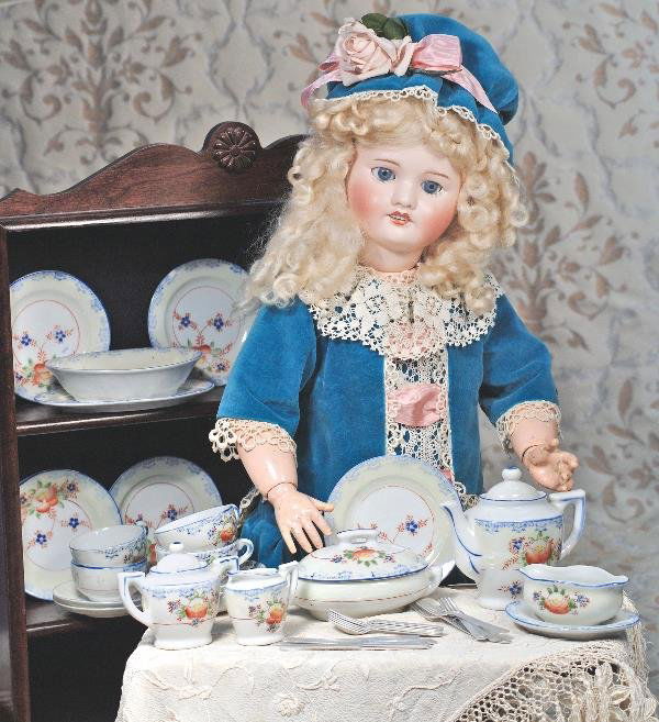 CHILD'S PORCELAIN TABLE SERVICE. Marks: Made i: CHILD'S PORCELAIN TABLE SERVICE. Marks: Made in Japan. Ivory and white background decorated with blue edging, motif and floral designs. Includes: lidded tea pot, sugar bowl, oval serving dish, oval pl