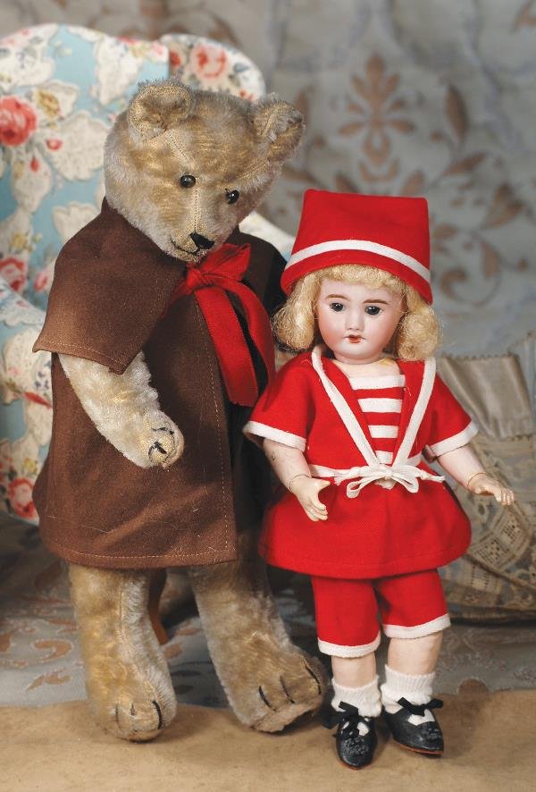 EARLY MOHAIR TEDDY BEAR. 14". Light gray/brown: EARLY MOHAIR TEDDY BEAR. 14". Light gray/brown mohair teddy bear, all straw filled, fully-jointed, button eyes, floss nose, mouth and claws, felt pads, wears brown woolen cloak. Commentary: Great pers