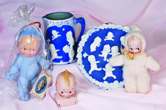 BLUE JASPERWARE GERMAN KEWPIE PITCHER AND WALL PLA: BLUE JASPERWARE GERMAN KEWPIE PITCHER AND WALL PLAQUE. Marks: Rose O'Neill, Kewpie, Germany/copyrighted. Pitcher 4 ½"; Plaque 6" diameter. Each piece is wedgewood blue jasperware with white embossed
