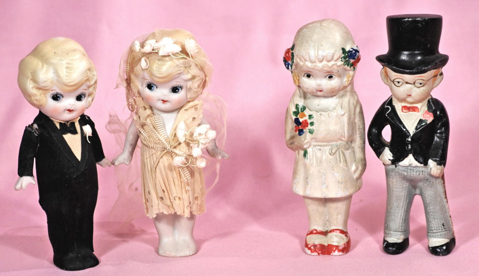 TWO SETS OF ALL-BISQUE BRIDE AND GROOM: TWO SETS OF ALL-BISQUE BRIDE AND GROOM. 5 1/2" to 6". Marks: Japan. One pair has jointed upper arms and paper costumes; One pair has molded and painted costumes and bodies; Each have molded and painte