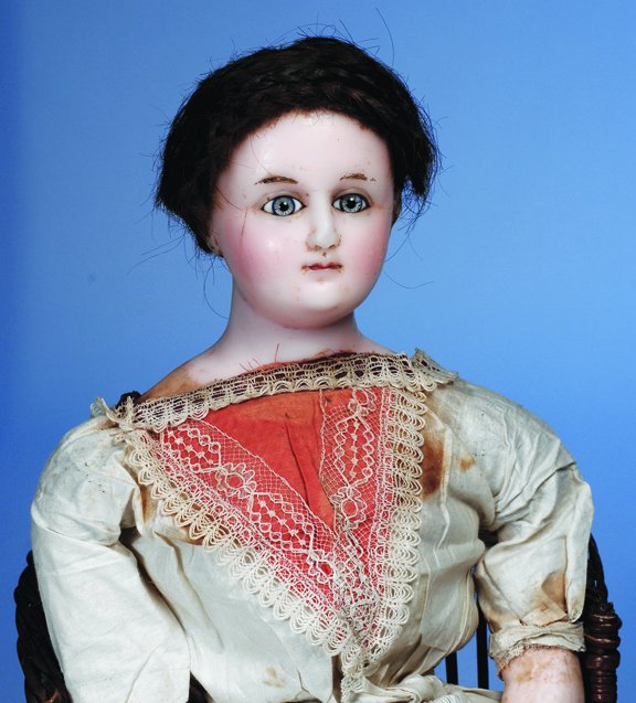 ENGLISH WAX-OVER-PAPIER MACHE DOLL WITH GLASS EYES: ENGLISH WAX-OVER-PAPIER MACHE DOLL WITH GLASS EYES. 24". Wax-over-papier mache shoulderhead with cut pate, inset blue paperweight eyes, molded eyelids, painted brows, closed mouth, blushed cheeks, pie
