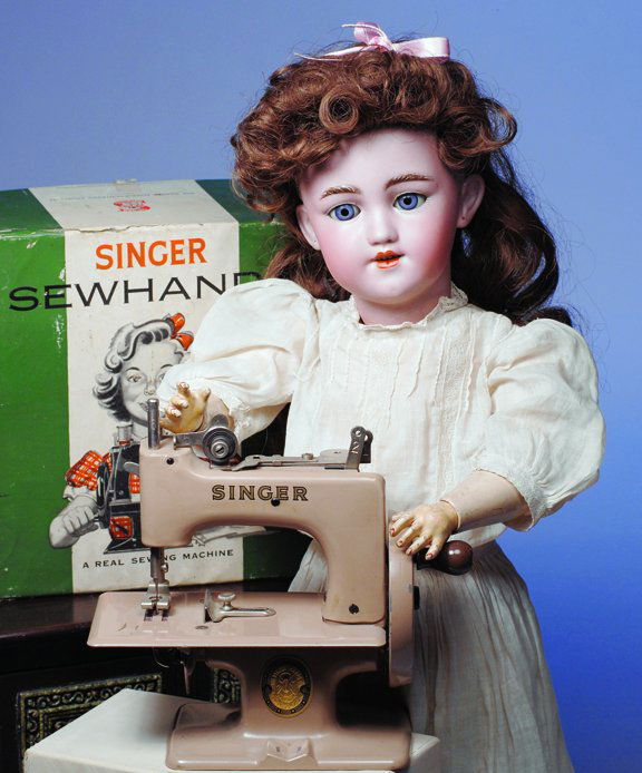 SINGER "SEW HANDY" SEWING MACHINE. Marks: Singer,: SINGER "SEW HANDY" SEWING MACHINE. Marks: Singer, made in Great Britain. 6 ½" H. Real child -size sewing machine with tan enamel finish, Singer name and emblem on front, separate metal clamp, in box