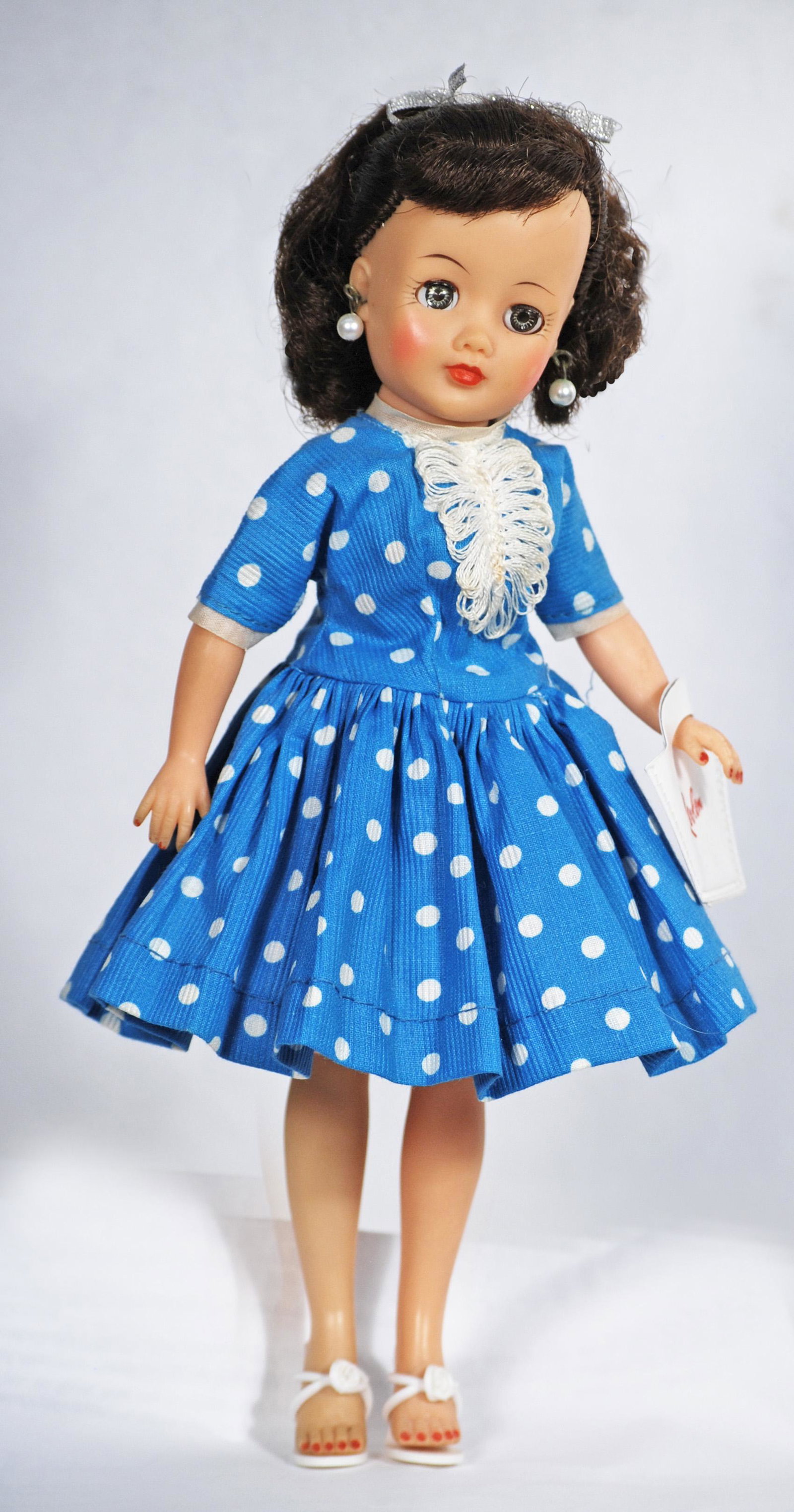 IDEAL LITTLE MISS REVLON IN POLKA DOT DRESS: IDEAL LITTLE MISS REVLON IN POLKA DOT DRESS. 10 1/2". Vinyl teen doll with swivel waist, rooted brunette hair, sleep eyes, wearing turquoise and white cotton polka dot dress with white trim, pink taff