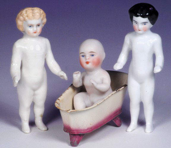 PAIR OF FROZEN CHARLOTTES. 4 ¾" and 5". Each is m: PAIR OF FROZEN CHARLOTTES. 4 ¾" and 5". Each is molded one-piece nude porcelain figure with molded and painted hair, painted features, blue eyes, closed mouth; blonde has molded boots and black-haire