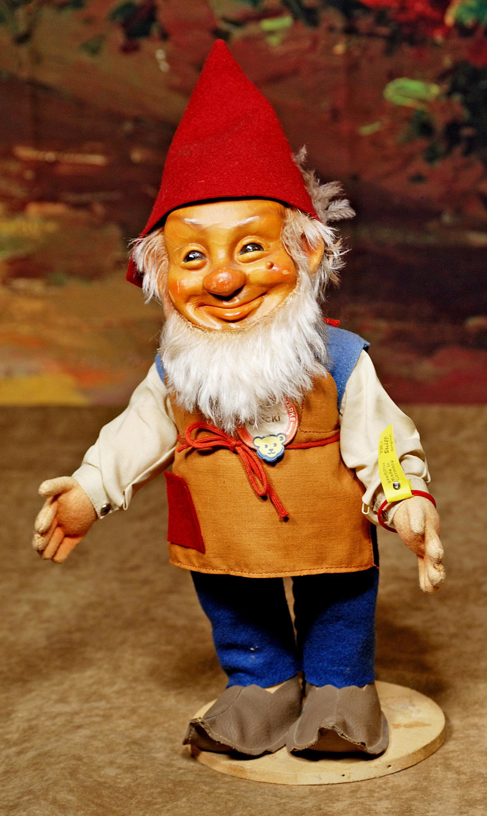 STEIFF DWARF "GUCKI" WITH TAGS AND BUTTON: STEIFF DWARF "GUCKI" WITH TAGS AND BUTTON. 15" H. (including hat). Molded rubber face with white mohair beard, jointed felt body, original costume, pointed shoes, felt hat, Gucki name tag, Steiff butt