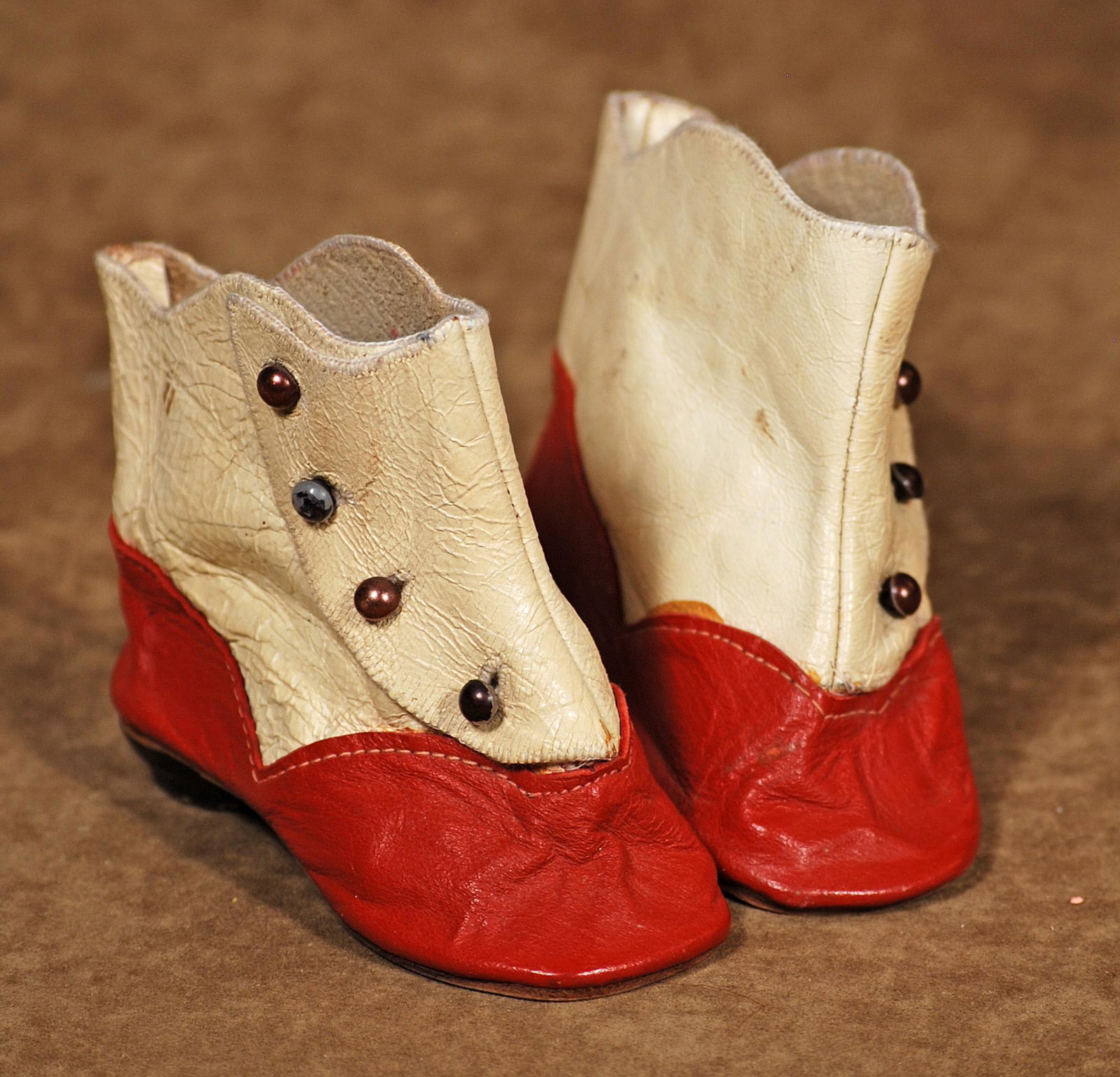 PAIR OF ANTIQUE DOLL BOOTS: PAIR OF ANTIQUE DOLL BOOTS. Red and white leather boots with side button closing, 4" length. Excellent condition.