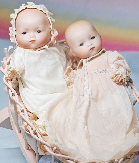 PAIR OF GERMAN BISQUE DREAM BABIES IN CRADLE. Mar: PAIR OF GERMAN BISQUE DREAM BABIES IN CRADLE. Marks: A.M. Germany 341. 9" baby on cloth body with celluloid arms & 8 ½" socket head baby on composition bent-limb body; each has painted blonde hair, b