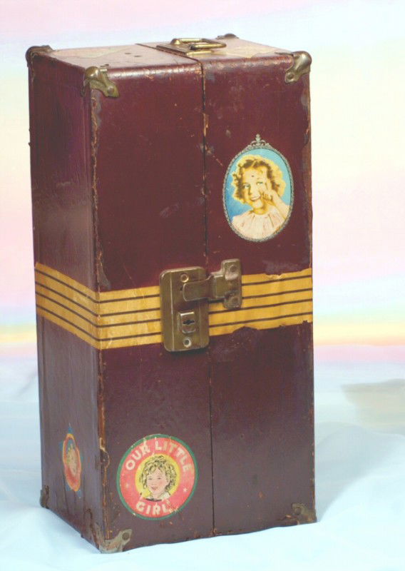 ORIGINAL SHIRLEY TEMPLE DOLL TRUNK: 15" x 7" x 6 1/2". Doll trunk with apppled covering and Shirley Temple labels, inside drawer and clothes rod.