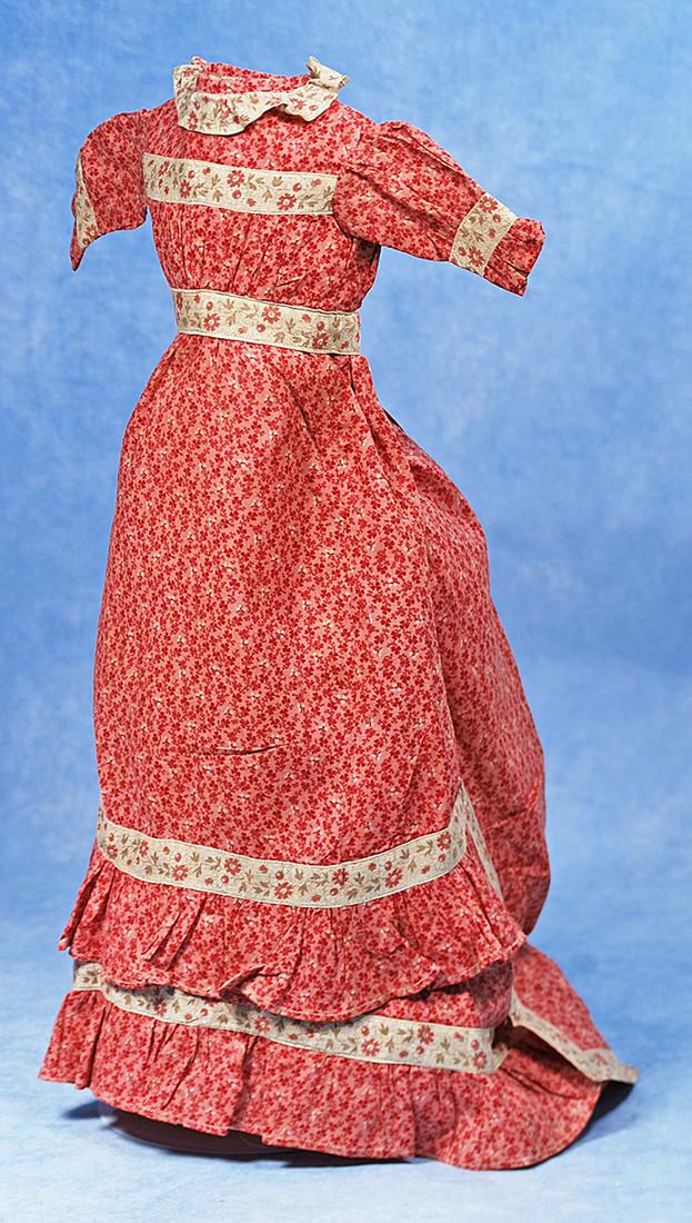 EARLY COTTON PRINT DAY DRESS FOR LADY DOLL: 175. EARLY COTTON PRINT DAY DRESS FOR LADY DOLL. Finely woven cotton with tiny transfer printed red/pink floral design, features slightly high waist with set-in waistband, gathered bodice, inset sleev