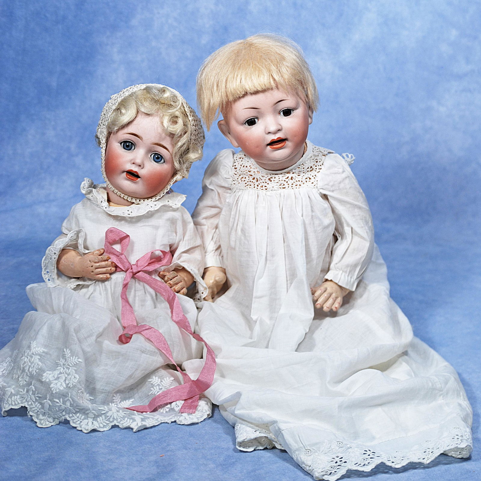 TWO GERMAN BISQUE CHARACTER BABIES: TWO GERMAN BISQUE CHARACTER BABIES. Each has bisque socket head, sleep eyes, open mouth, accented lips, upper teeth, wig, composition baby body, white cotton dress. Includes: 12” JDK 257 with bl