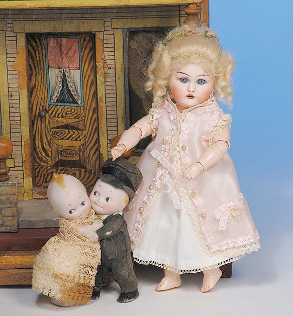 GERMAN BISQUE KEWPIE BRIDE & GROOM HUGGERS: 3 ¾". All-bisque Kewpie figures with molded hair and topknot, painted features with side-glancing eyes, original crepe paper and lace costumes. Commentary: All-original, excellent condition.