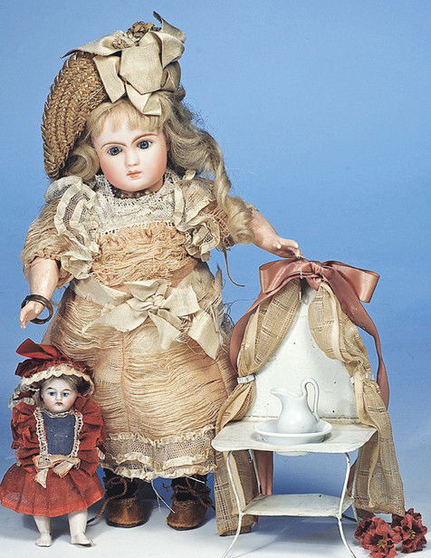 MINIATURE TIN DOLL'S WASHSTAND: 6 ½" H. Painted white metal stand with high back, cloth and ribbon curtain, curved legs, lower shelf, white china pitcher and bowl. Commentary: Nice accessory for miniature dolls, good condition.