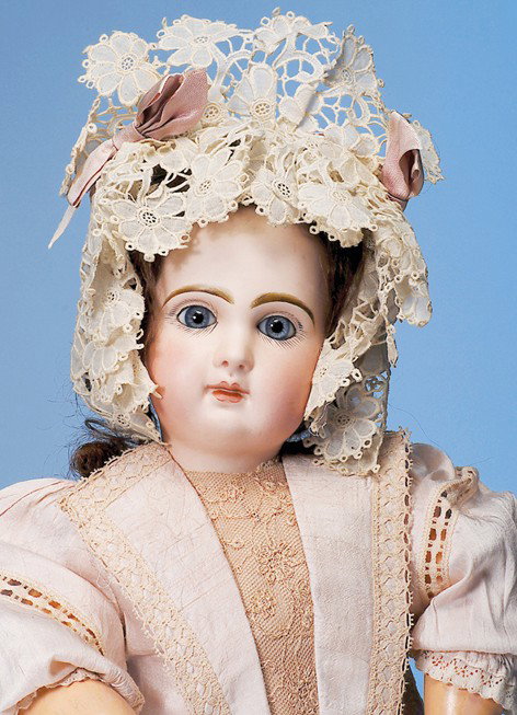 FRENCH BISQUE BEBE BY JUMEAU WITH LUSCIOUS COMPLEX: Marks: 9. 21". Bisque socket head, blue paperweight eyes, painted lashes, eyeliner, feathered and brushstroked brows, pierced ears, closed mouth, shaded and accented lips, brunette human hair wig, cor