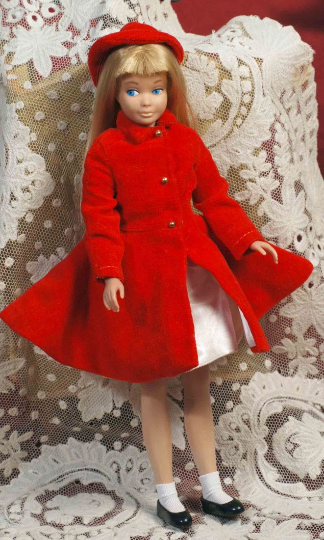 1964 MATTEL “SKIPPER” IN “SILK ‘N FANCY” OUTFIT WI: 1964 MATTEL “SKIPPER” IN “SILK ‘N FANCY” OUTFIT WITH RED VELVET COAT AND HAT. 9” vinyl doll with long blonde hair and bangs, tagged red velvet and white satin dress with hidden lace ruffle