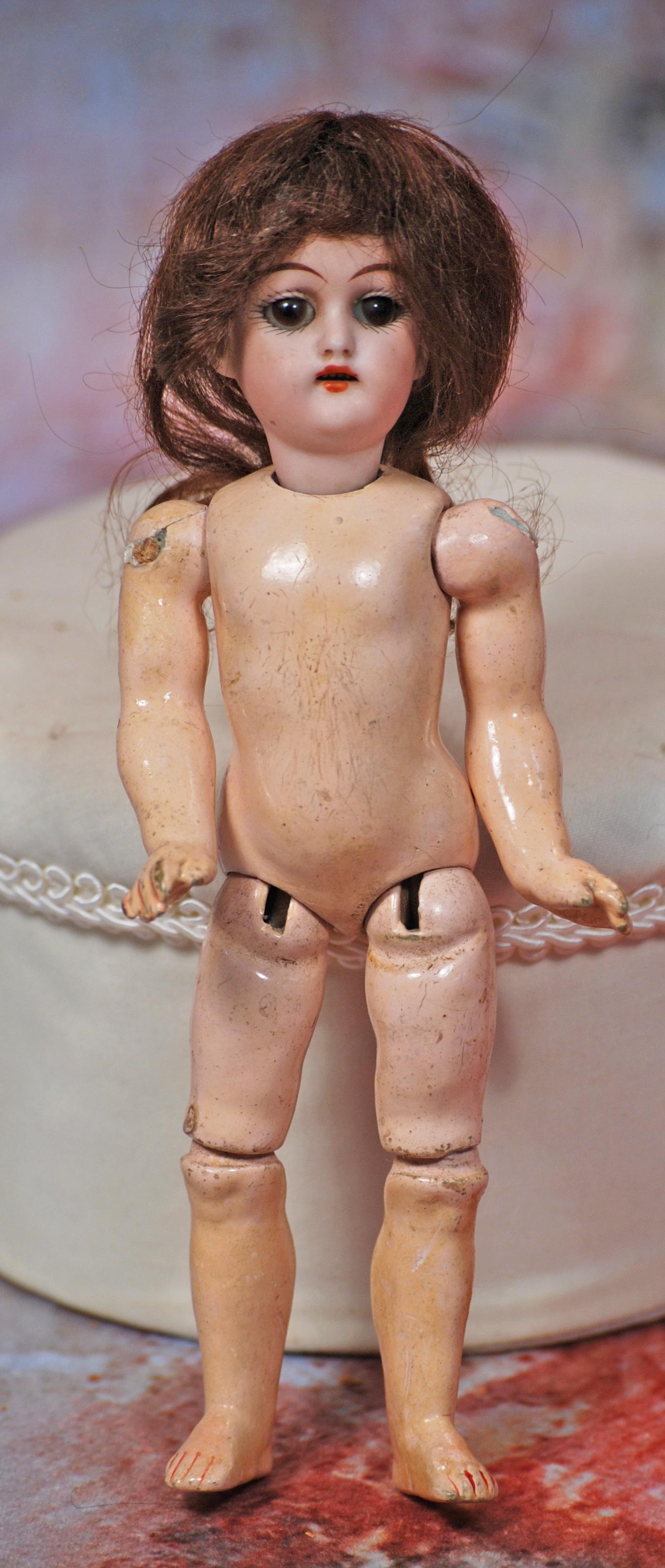 MINIATURE GERMAN BISQUE DOLL: MINIATURE GERMAN BISQUE DOLL. 7”. Marks: 189-38. Bisque socket head, brown sleep eyes, painted lashes, tapered brows, open mouth, upper teeth, original brown mohair wig, original composition joi