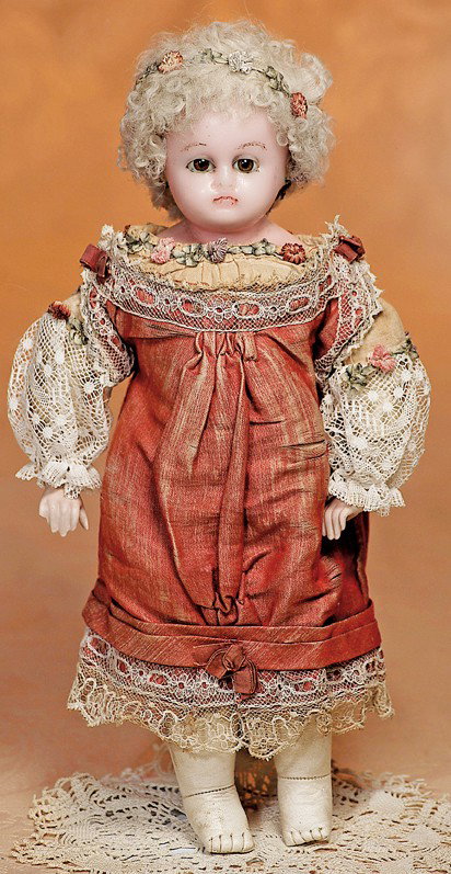 GERMAN WAX-OVER-PAPIER MACHE DOLL: GERMAN WAX-OVER-PAPIER MACHE DOLL. 13". Wax-over shoulderhead with solid dome, inset brown glass eyes, painted brows, closed mouth, pierced-in ears, blonde lambs wool wig, plumply-modelled kid body wi