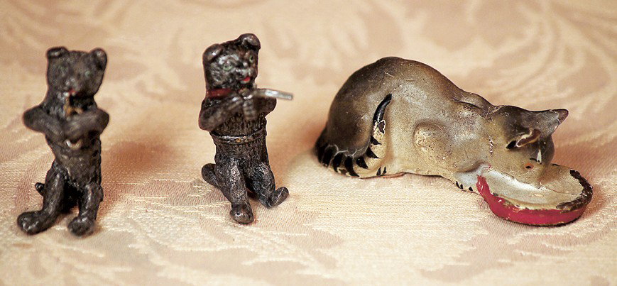 MINIATURE BEARS & KITTEN: MINIATURE BEARS & KITTEN. Lot includes: 1 ¾" pewter bear playing trumpet, 1 ¾" pewter bear firing rifle; and 2 ½" x 1" composition cat at feeding dish. Commentary: All in good condition.