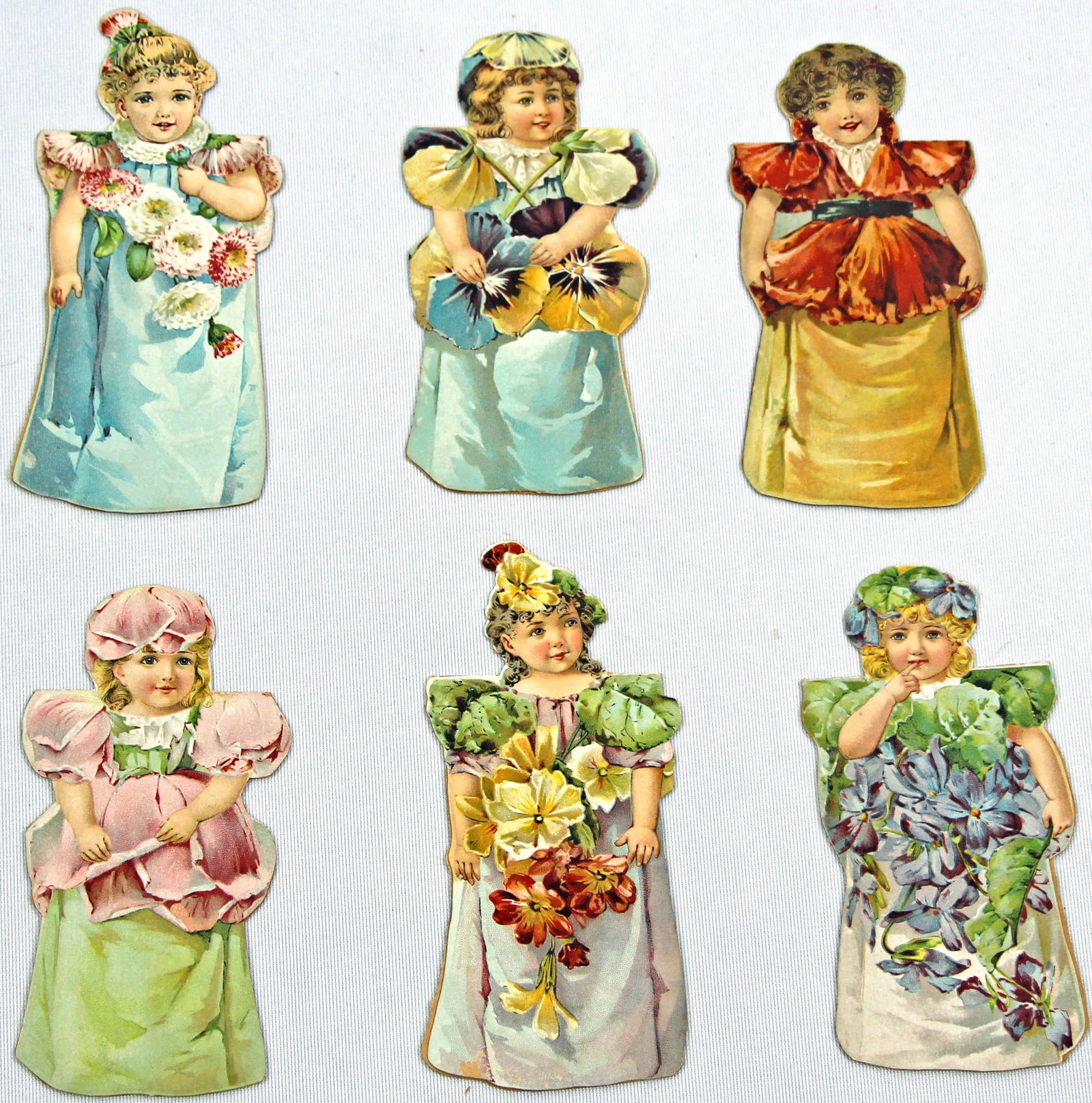 SET OF 6 ENAMELINE ADVERTISEMENT FLOWER PAPER DOLLS, 1890s: 62. SET OF 6 ENAMELINE ADVERTISEMENT FLOWER PAPER DOLLS, 1890s. 5" dolls with pop out stand: Rose, Pansy, Poppy, Chrysanthemum, Violet, and Primrose, with Enameline advertisement information printed i