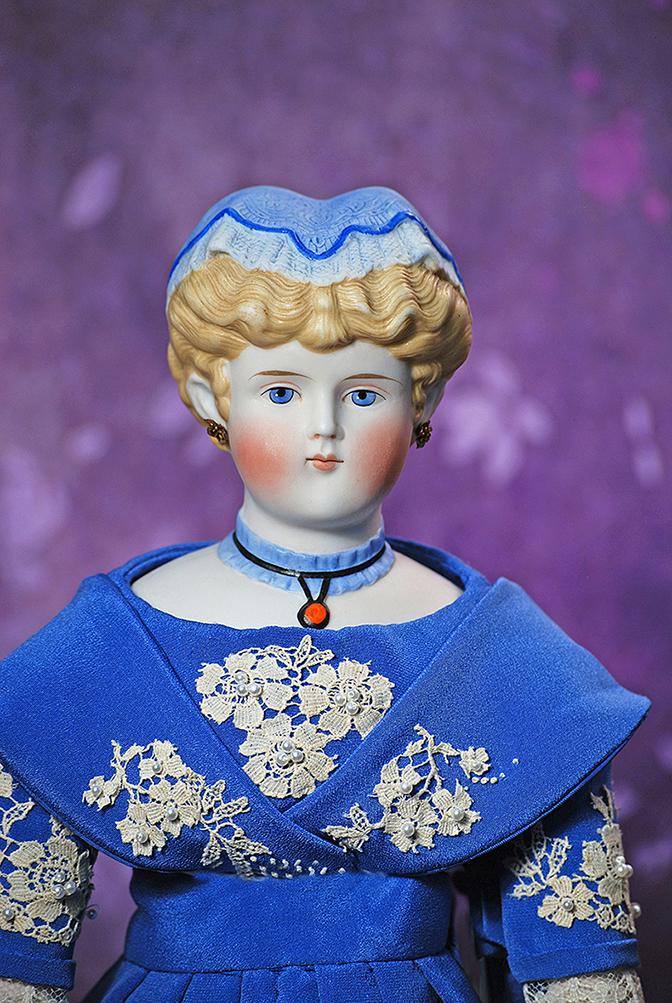 GERMAN BISQUE LADY WITH SCULPTED BLUE CAP AND RUFFLED COLLAR. 21”. Bisque shoulderhead with: GERMAN BISQUE LADY WITH SCULPTED BLUE CAP AND RUFFLED COLLAR. 21”. Bisque shoulderhead with oval face, blonde sculpted hair drawn from face in deeply-defined waves behind her pierced ears, and c