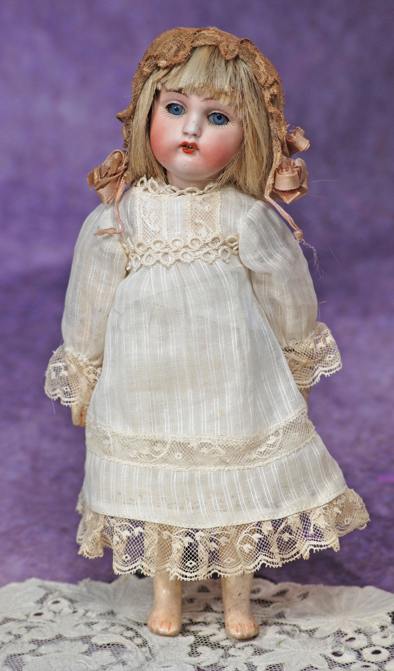 PETITE GERMAN BISQUE CHILD BY KESTNER. 8 ½”. Marks: made in Germany 159. Bisque socket: PETITE GERMAN BISQUE CHILD BY KESTNER. 8 ½”. Marks: made in Germany 159. Bisque socket head, blue sleep eyes, painted lashes, feathered brows, open mouth, upper teeth, blonde human hair wig