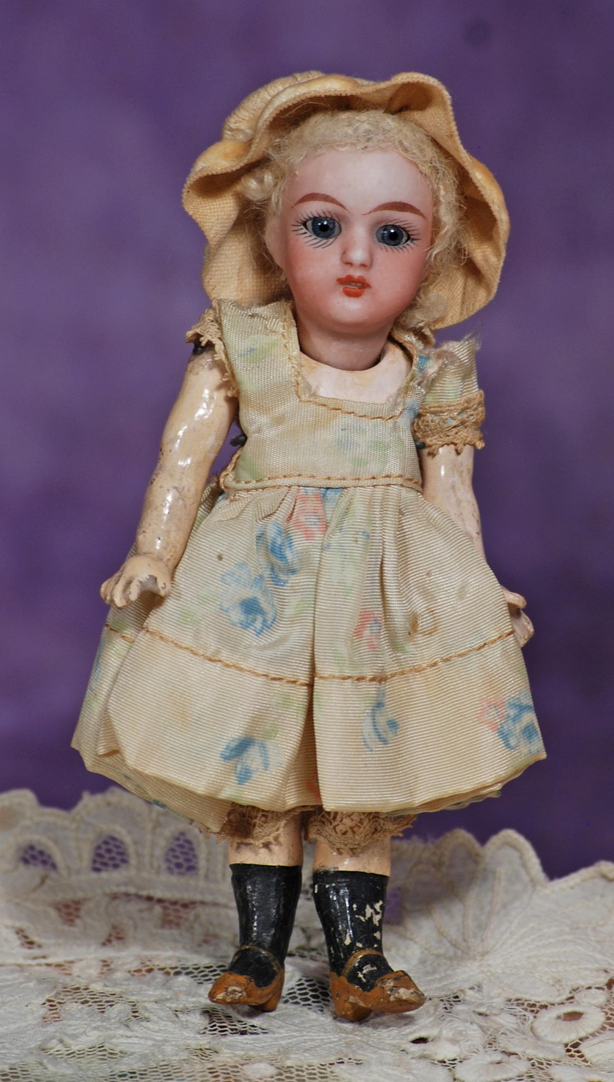 MINIATURE GERMAN BISQUE DOLL. 5”. Marks: None visible. Bisque socket head, inset blue glass: MINIATURE GERMAN BISQUE DOLL. 5”. Marks: None visible. Bisque socket head, inset blue glass eyes, painted lashes, tapered brows, slightly parted lips with square-cut upper teeth, original lambs