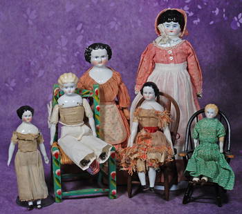 GROUP OF SIX GERMAN CHINA DOLLS. 8” to 15”. Each is porcelain shoulderhead with painted: GROUP OF SIX GERMAN CHINA DOLLS. 8” to 15”. Each is porcelain shoulderhead with painted hair and features, cloth body; three dolls seated in chairs; two in original garments. Commentary: O