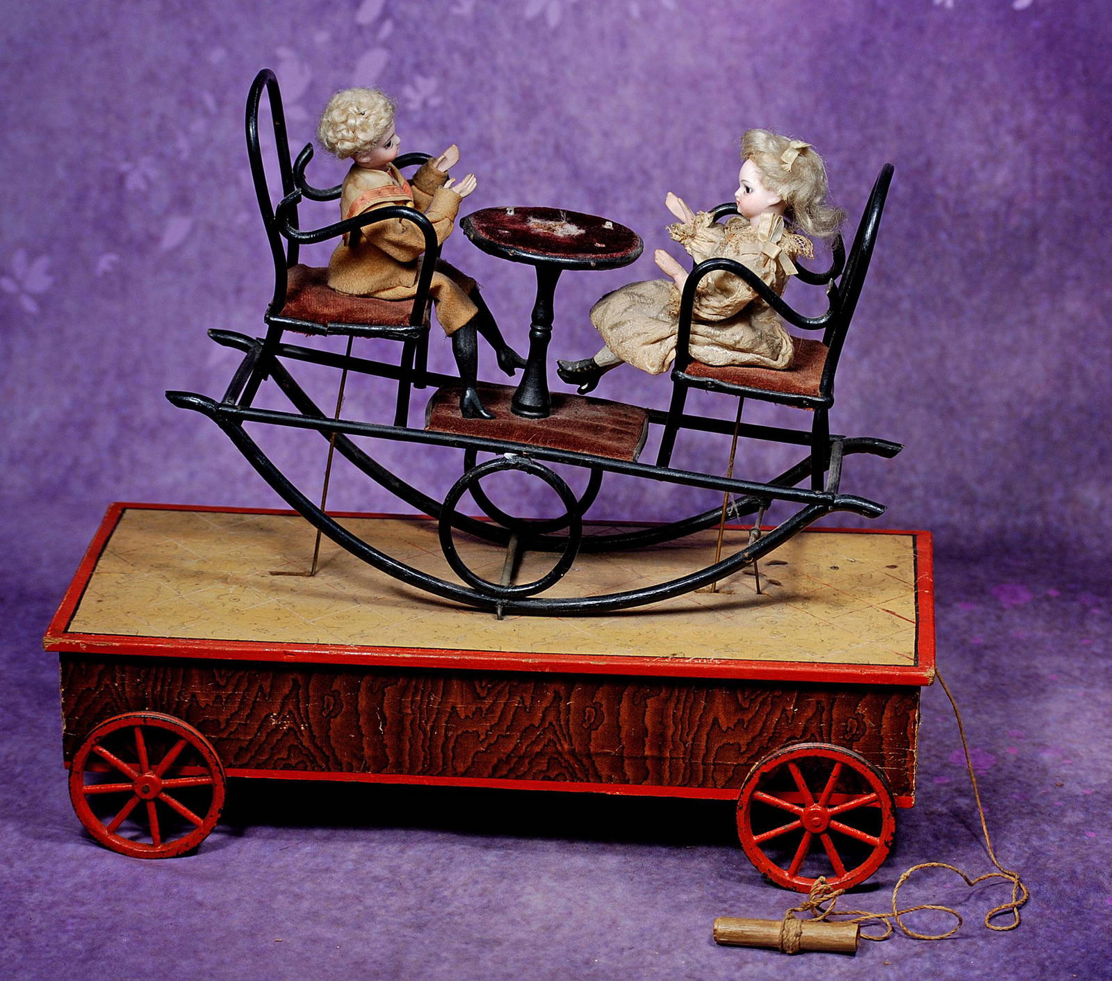 FRENCH MECHANICAL PULL TOY “DOLLS AT TEA TIME”. 13” L. x 12” H. Two