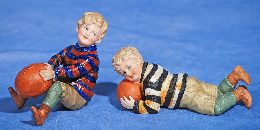 PAIR OF HEUBACH ALL-BISQUE BOYS WITH FOOTBALL. (1 of 1)