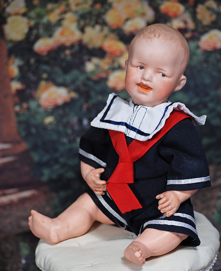 HEUBACH BISQUE CHARACTER BABY: GERMAN BISQUE CHARACTER WITH CROOKED SMILE BY HEUBACH. 9 1/2". Marks: Heubach 8191 Germany. Bisque socket head with sculpted hair portraying happy child with crooked smile, sculpted, intaglio side-gla