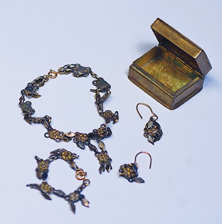 ANTIQUE DOLL JEWELRY IN BRASS JEWELRY BOX. 1” W. : ANTIQUE DOLL JEWELRY IN BRASS JEWELRY BOX. 1” W. brass box with hinged lid contains set of ornate em-bossed metal doll jewelry comprised of necklace, bracelet and earrings. Commentary: Beautifully d