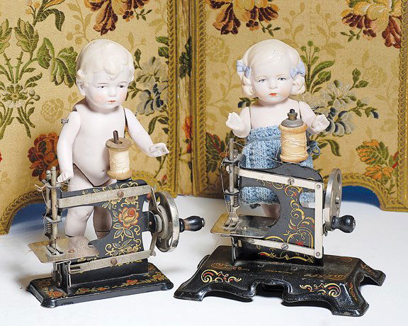 TWO GERMAN TOY SEWING MACHINES WITH DECORATIVE PA: TWO GERMAN TOY SEWING MACHINES WITH DECORATIVE PAINTING. Each is painted black enamel with elaborate red and gold stenciled designs, nickel plated wheel and base plate, wooden knob; 4 ½” machine ma