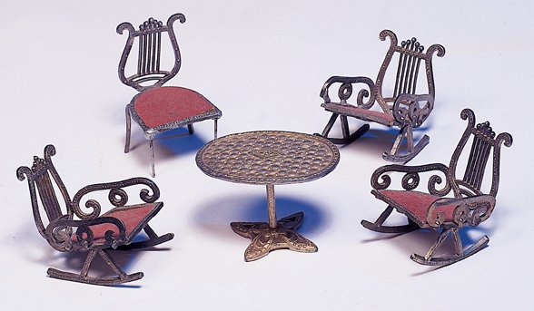 DOLL HOUSE METAL FURNITURE GROUP. Marks: Made in : DOLL HOUSE METAL FURNITURE GROUP. Marks: Made in U. S. A. Pat. Pend. Embossed gilt metal furniture includes oval pedestal table, four chairs with rose-covered wooden seats, includes one side chair and