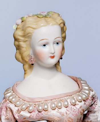 GERMAN BISQUE PARIAN LADY WITH FLORAL HAIR DECORA: GERMAN BISQUE PARIAN LADY WITH FLORAL HAIR DECORATION. 18 ½”. Bisque shoulderhead, molded and painted blonde hair waved away from face with curls cascading onto shoulders, decorated with pink Dresd