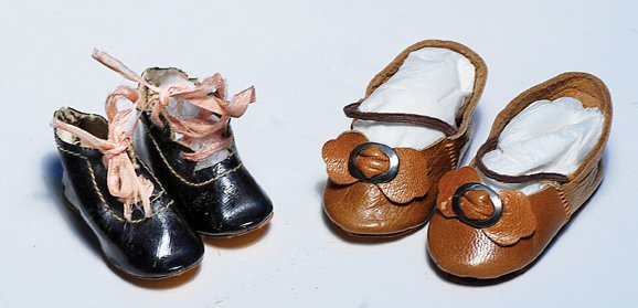 TWO PAIR OF ANTIQUE DOLL SHOES. Includes: 2” L. b: TWO PAIR OF ANTIQUE DOLL SHOES. Includes: 2” L. black leather-cloth shoes with pink stitching around edges, and pink silk ties; plus 2 ¼” L. Camel tan leather shoes with leather bows and silver b