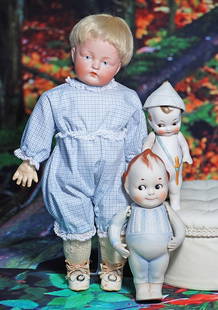 TWO GERMAN ALL-BISQUE CHARACTERS. (1) 6 &#189;&#8221; doll jointed at shoulders, brown sculpted: TWO GERMAN ALL-BISQUE CHARACTERS. (1) 6 &#189;&#8221; doll jointed at shoulders, brown sculpted hair, topknot, forelock, side-glancing brown eyes, dash brows, impish smile, painted blue pajamas, bare