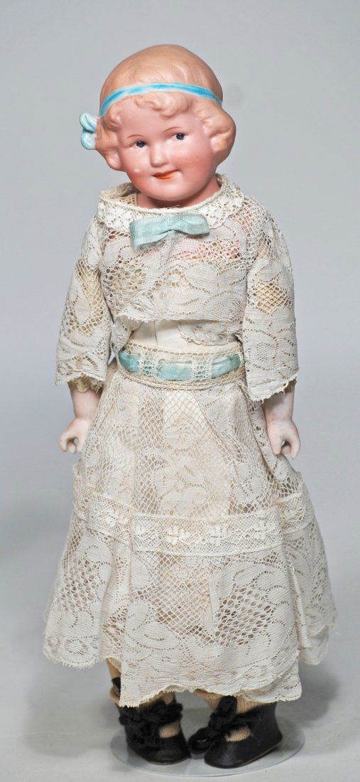 GEBRUDER HEUBACH â€œCOQUETTE” BISQUE CHARACTER GIRL: 62, GEBRUDER HEUBACH â€œCOQUETTE” BISQUE CHARACTER GIRL. 11”. Bisque shoulderhead, sculpted dark blonde hair, with aqua blue glazed hair ribbon, painted features, intaglio blue eyes, o